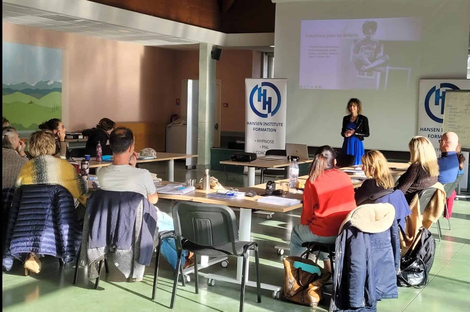 Sandrine Hansen anime la formation hypnose avec les enfants au Hansen Institute, devant un groupe de stagiaires